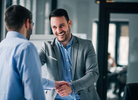 Portrait of cheerful young manager handshake with new employee.