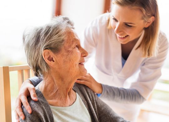 Health visitor and a senior woman during home visit.