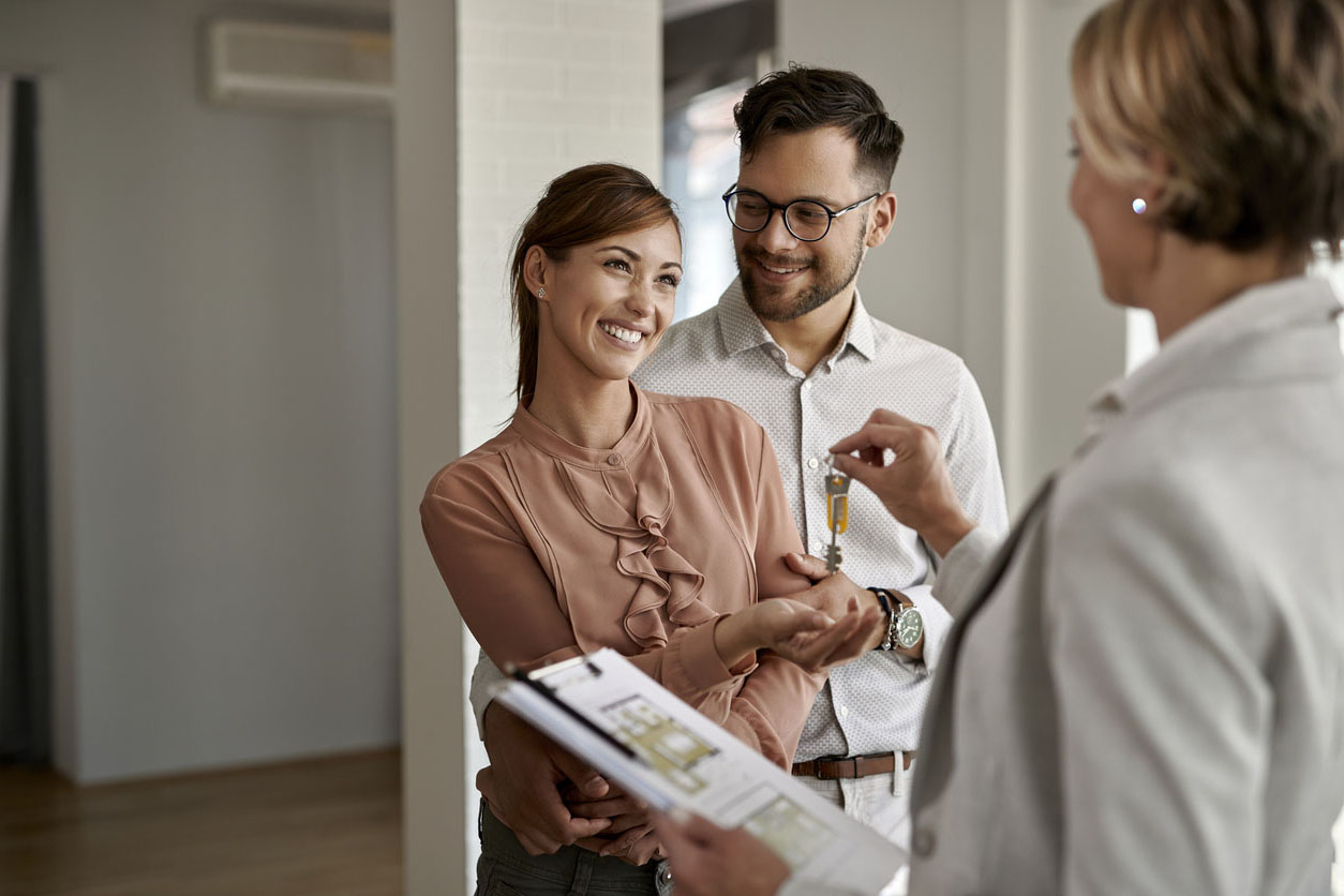 jeune couple qui recoit les clefs de son logement neuf