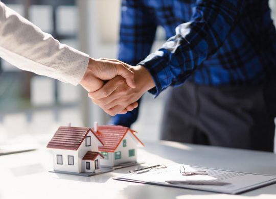 Propriétaire et locataire se serrent la main pour une nouvelle maison