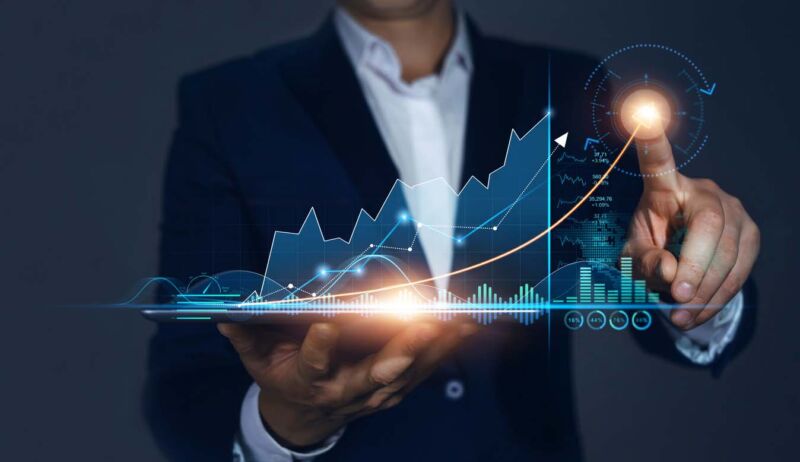 Homme d’affaires tenant une tablette et dessine un hologramme virtuel croissant de statistiques